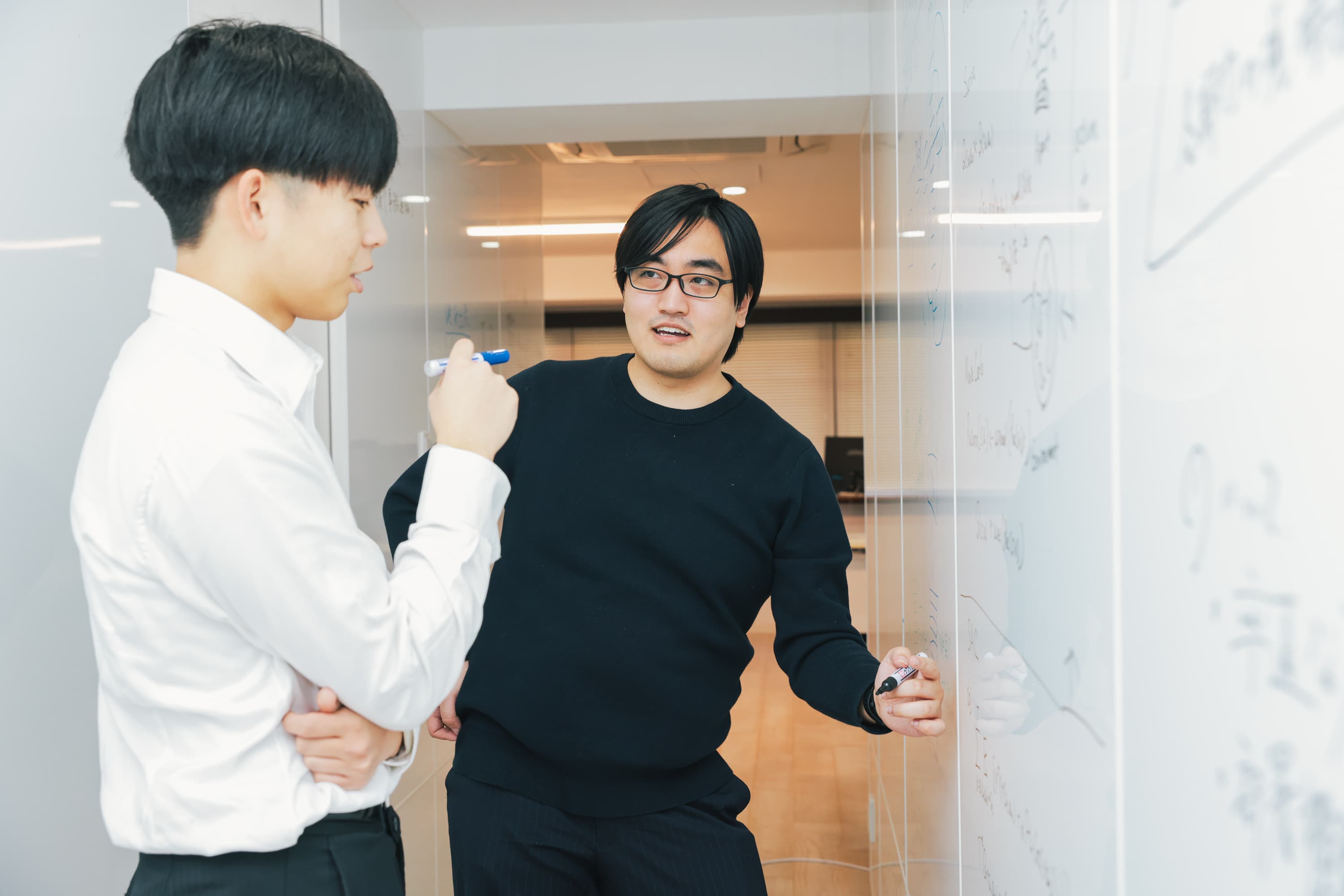 ホワイトボードに図を描きながら議論するAirionのエンジニア
