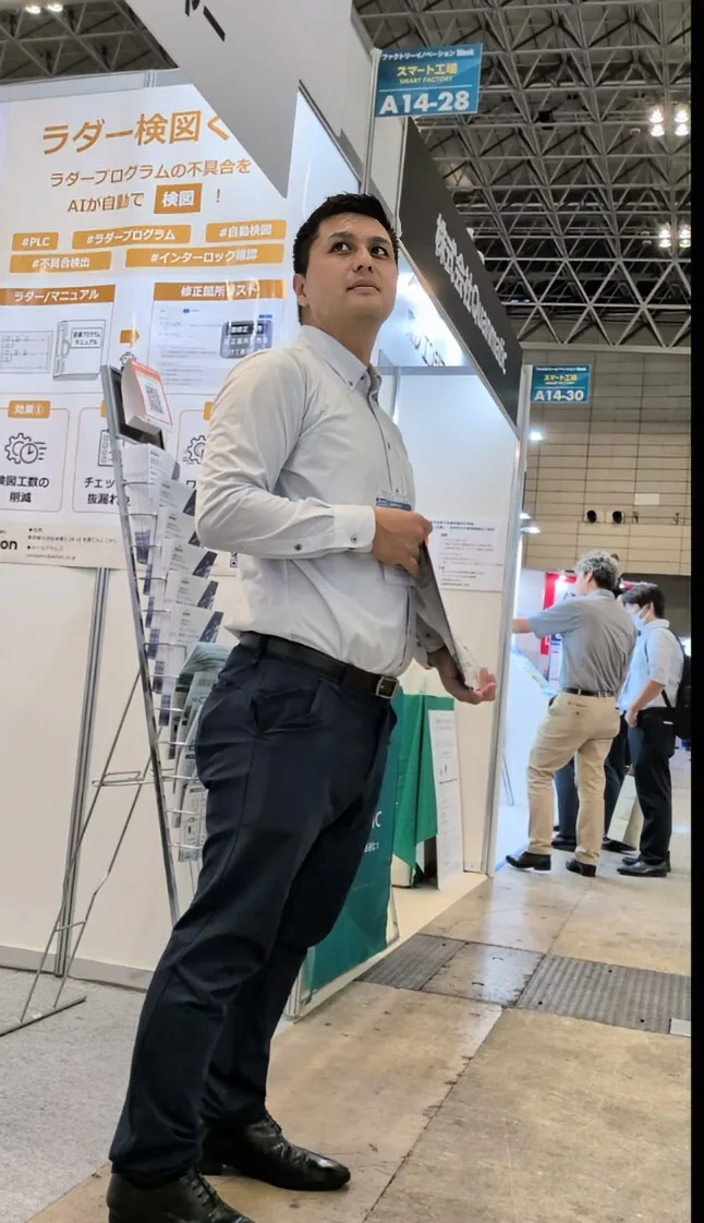 展示会ブースで来場者に説明する小林直弥