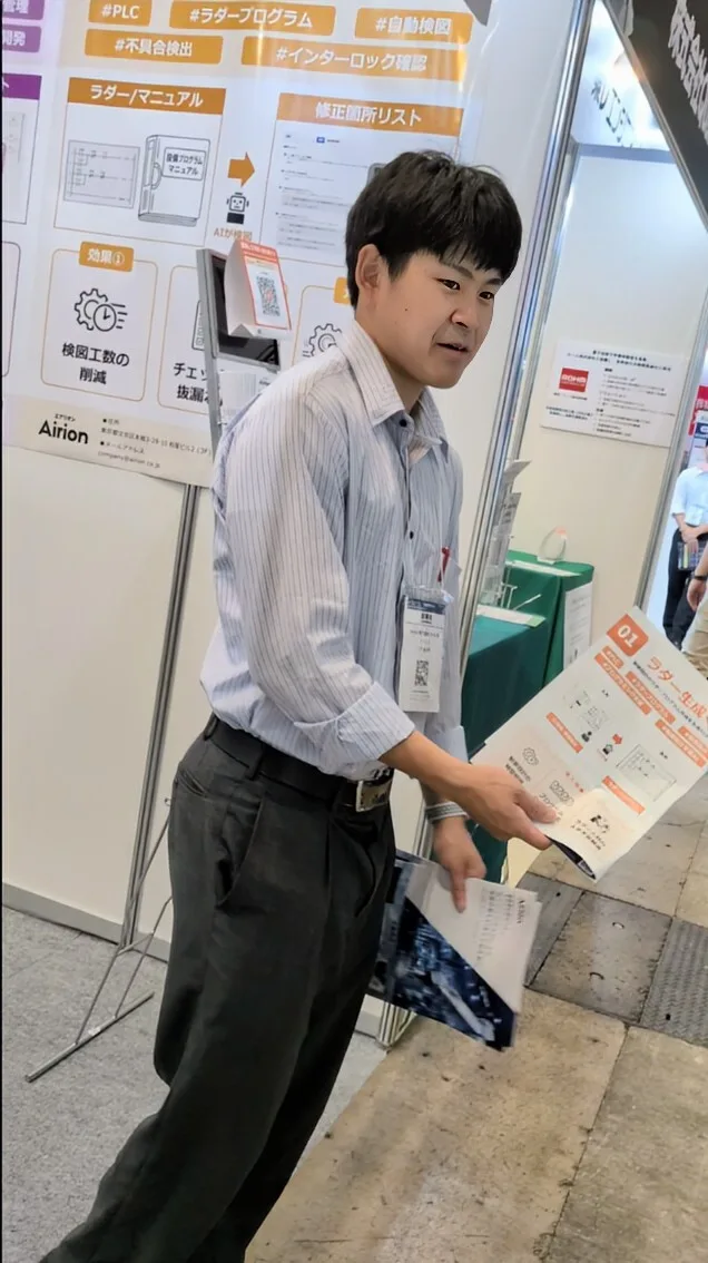 展示会ブースで来場者に説明する営業の土屋裕太郎